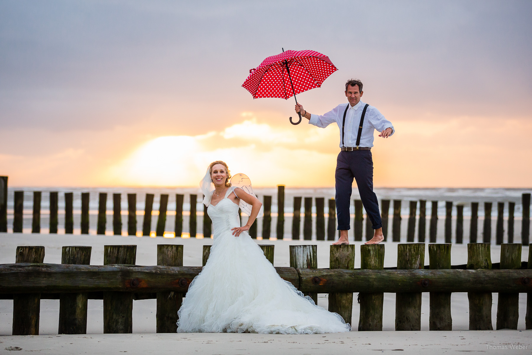 Hochzeitsfotograf auf Wangerooge, moderne Hochzeitsfotos mit Hochzeitskleid am Strand bei Sonnenuntergang, Hochzeitsfotograf Thomas Weber aus Oldenburg