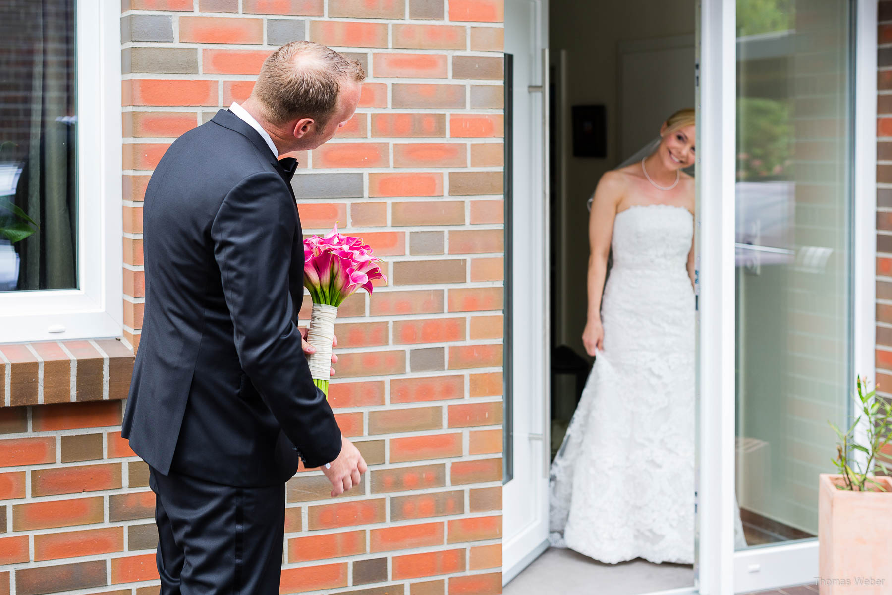 Der Bräutigam holt seine Braut mit dem Hochzeitsauto und Brautstrauß ab, Hochzeitsfotograf Oldenburg Thomas Weber
