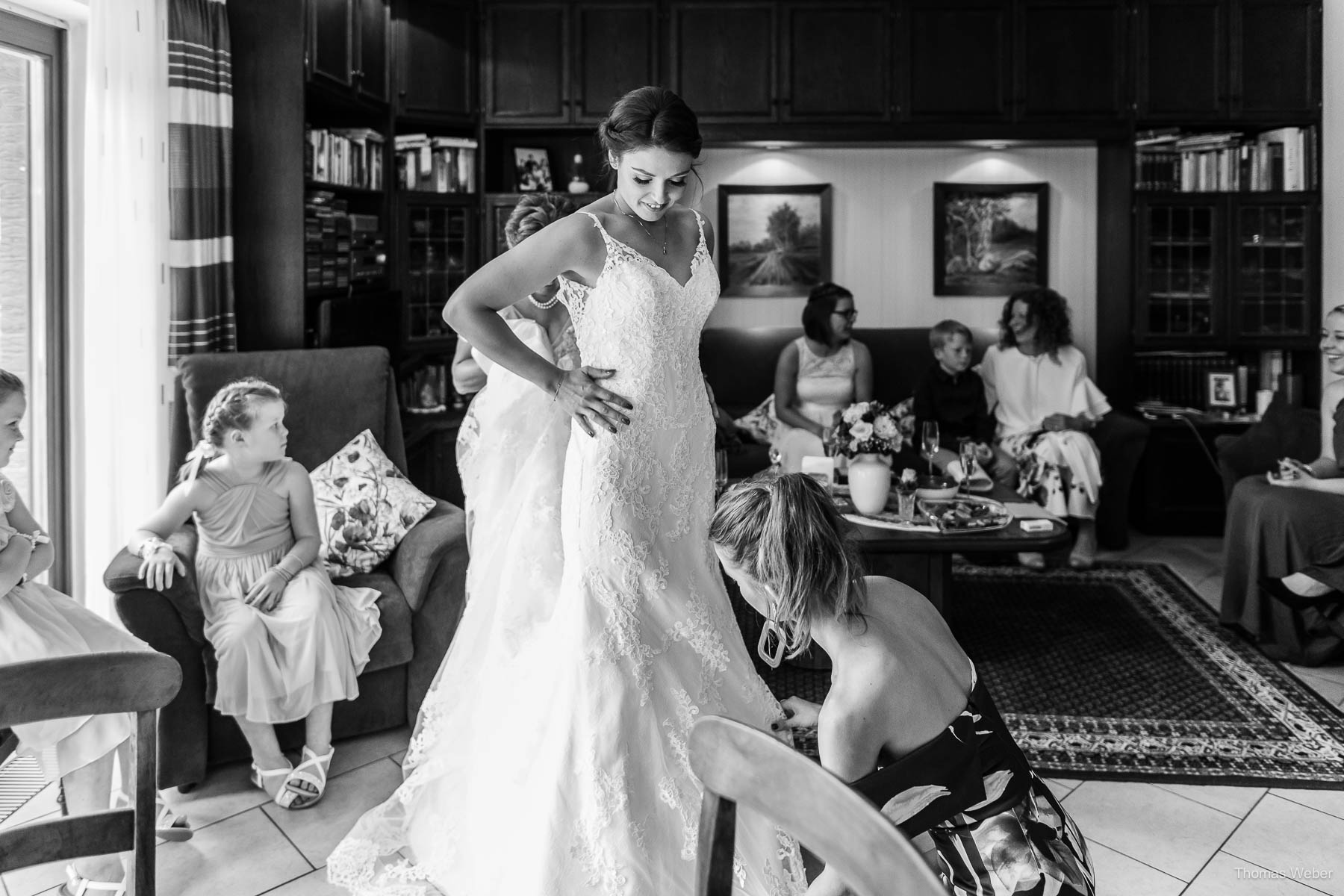 Die Braut zieht ihr Hochzeitskleid an und begrüßt Freunde & Familie, Thomas Weber, Hochzeitsfotograf in Wildeshausen
