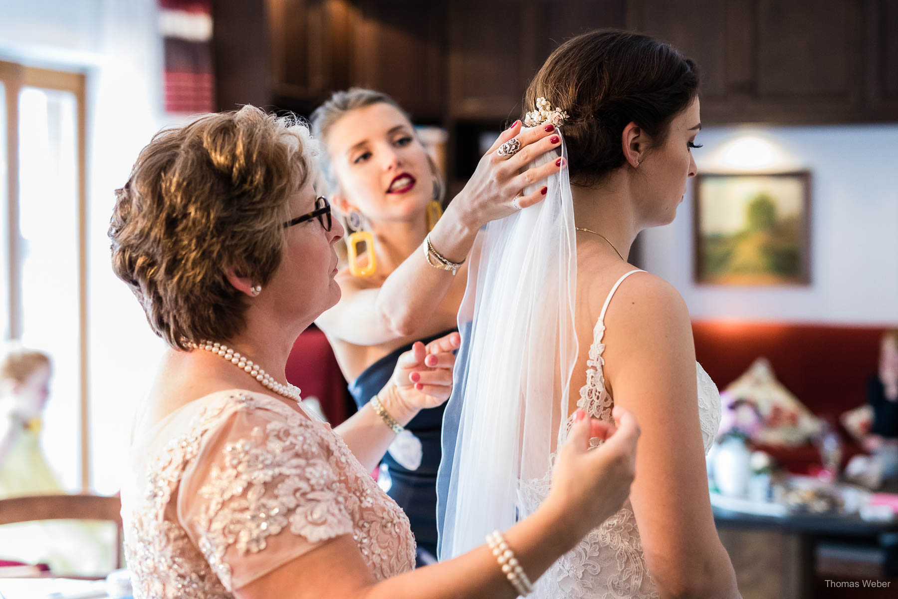 Die Braut zieht ihr Hochzeitskleid an und begrüßt Freunde & Familie, Thomas Weber, Hochzeitsfotograf in Wildeshausen